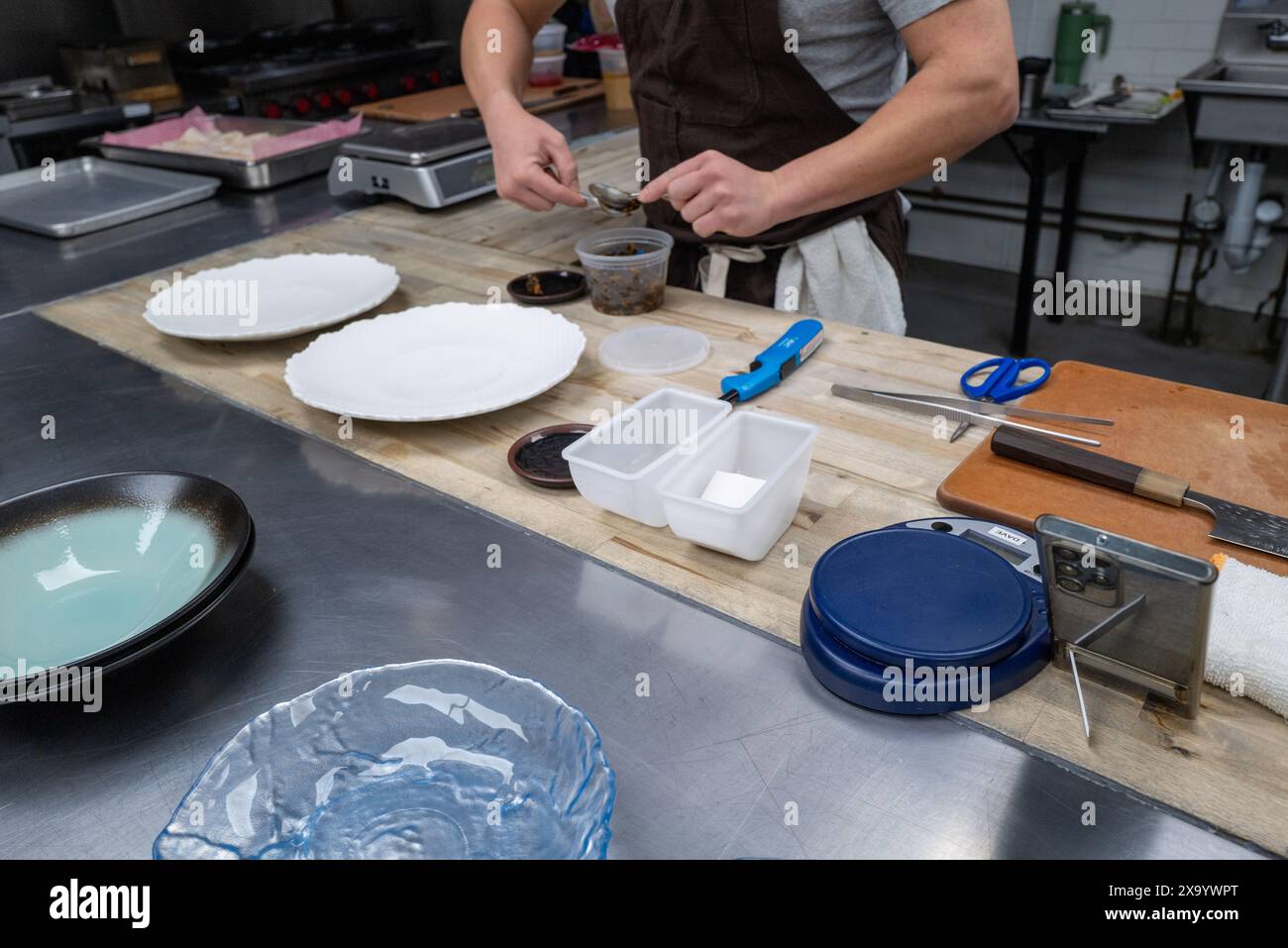 Un uomo che cucina su un tavolo da cucina di metallo Foto Stock