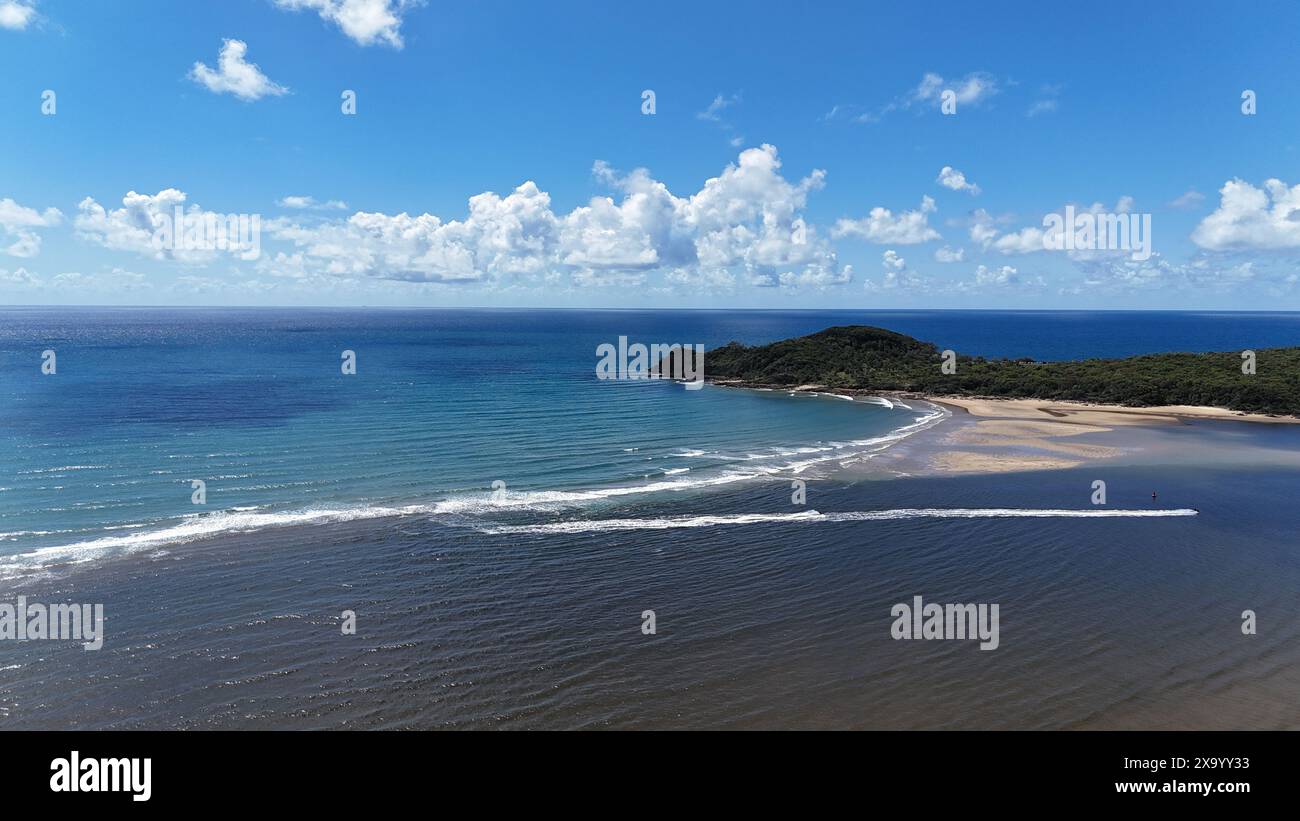 Una spiaggia sabbiosa con dolci onde che si infrangono sulla riva Foto Stock