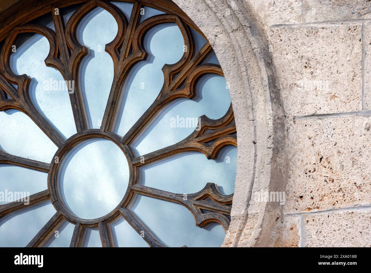 Frammento di finestra gotica rotonda con cornice in legno in parete di pietra, foto di sfondo di architettura astratta Foto Stock