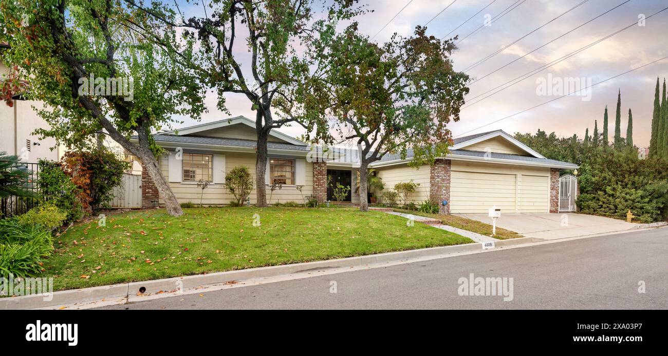 Una casa residenziale di fronte a un cartello stradale con un nome chiaramente visibile a Encino, CA Foto Stock