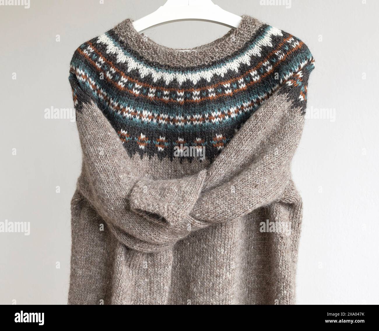Foto di un maglione in lopapeysa in lana lavorata a maglia tradizionale islandese con le maniche legate, pullover beige marrone con un grande motivo colorato Foto Stock