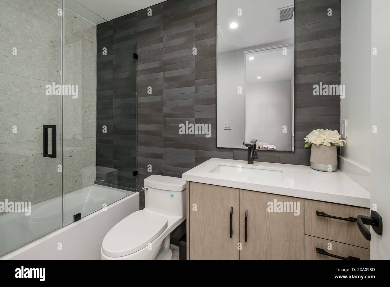 Bagno bianco con box doccia e vasca ad angolo Foto Stock