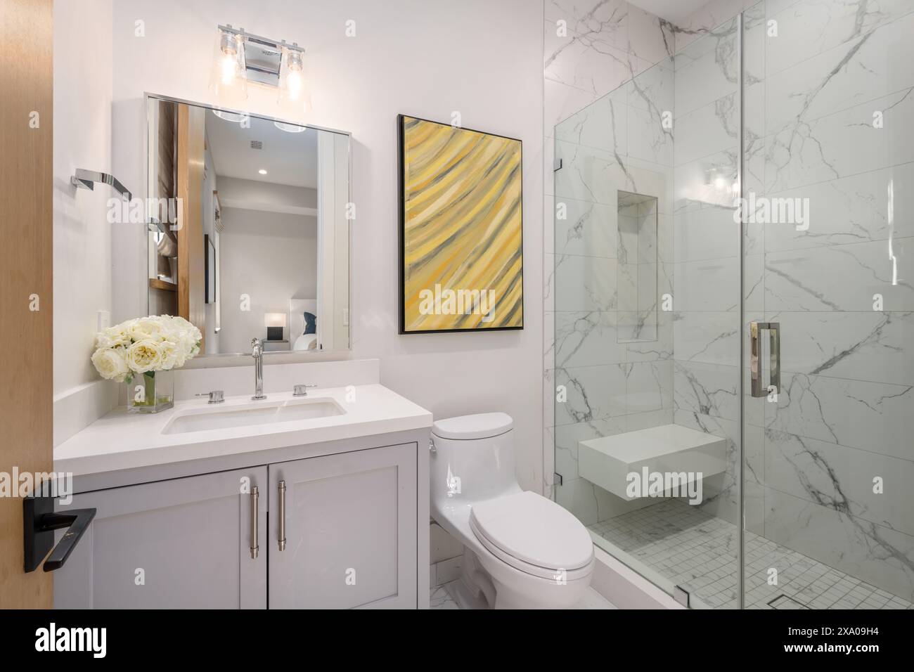 Bagno con ripiano in marmo, finiture bianche e dettagli in marmo Foto Stock