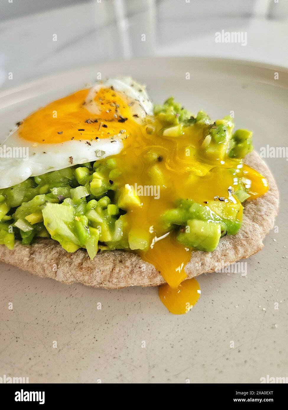 Un delizioso panino a vista con avocado e un uovo fritto Foto Stock