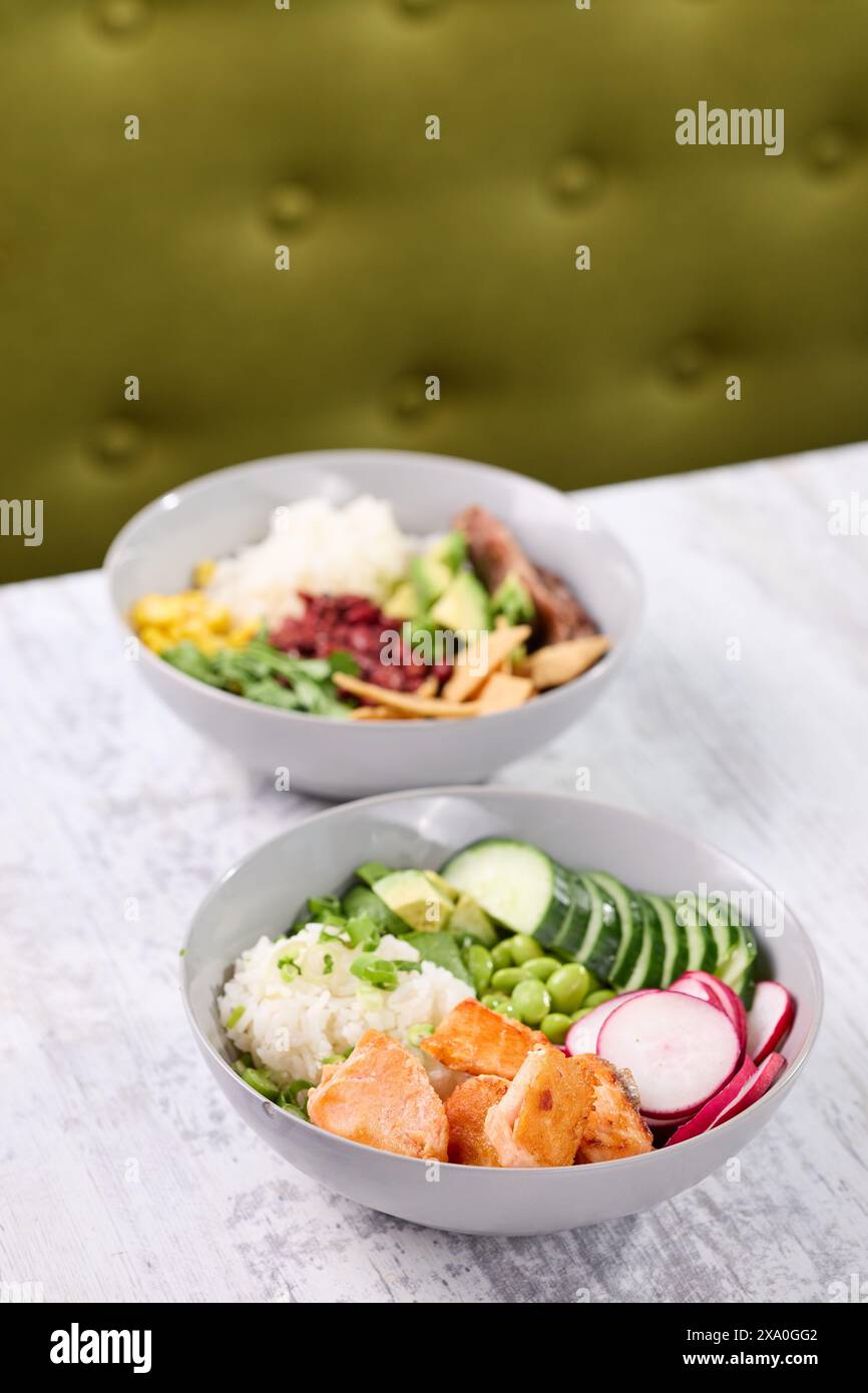 Due ciotole di insalate fresche su un tavolo accanto a una sedia verde Foto Stock