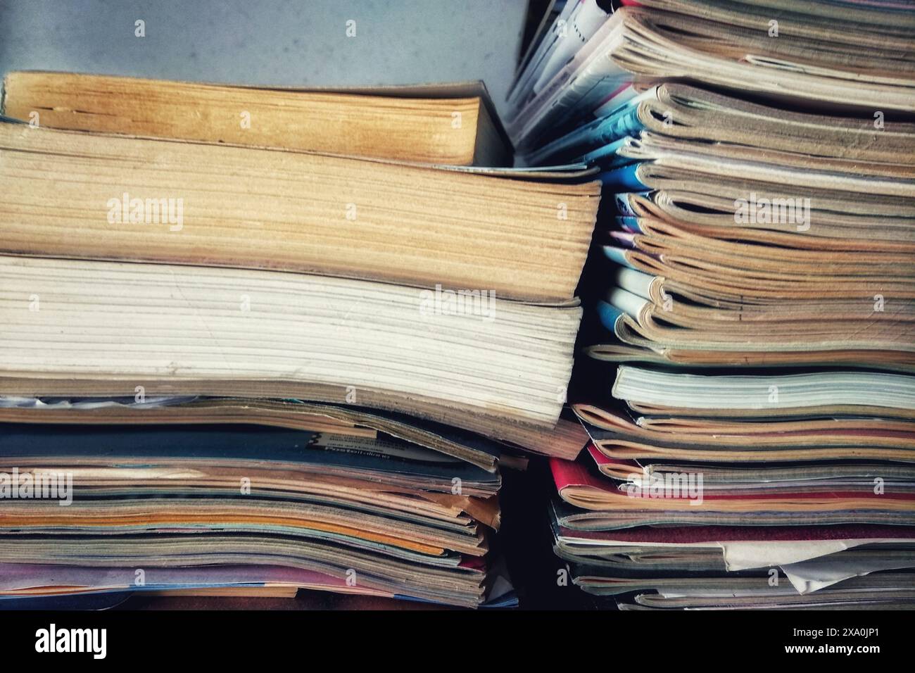 Una pila di giornali vicino a uno scaffale Foto Stock