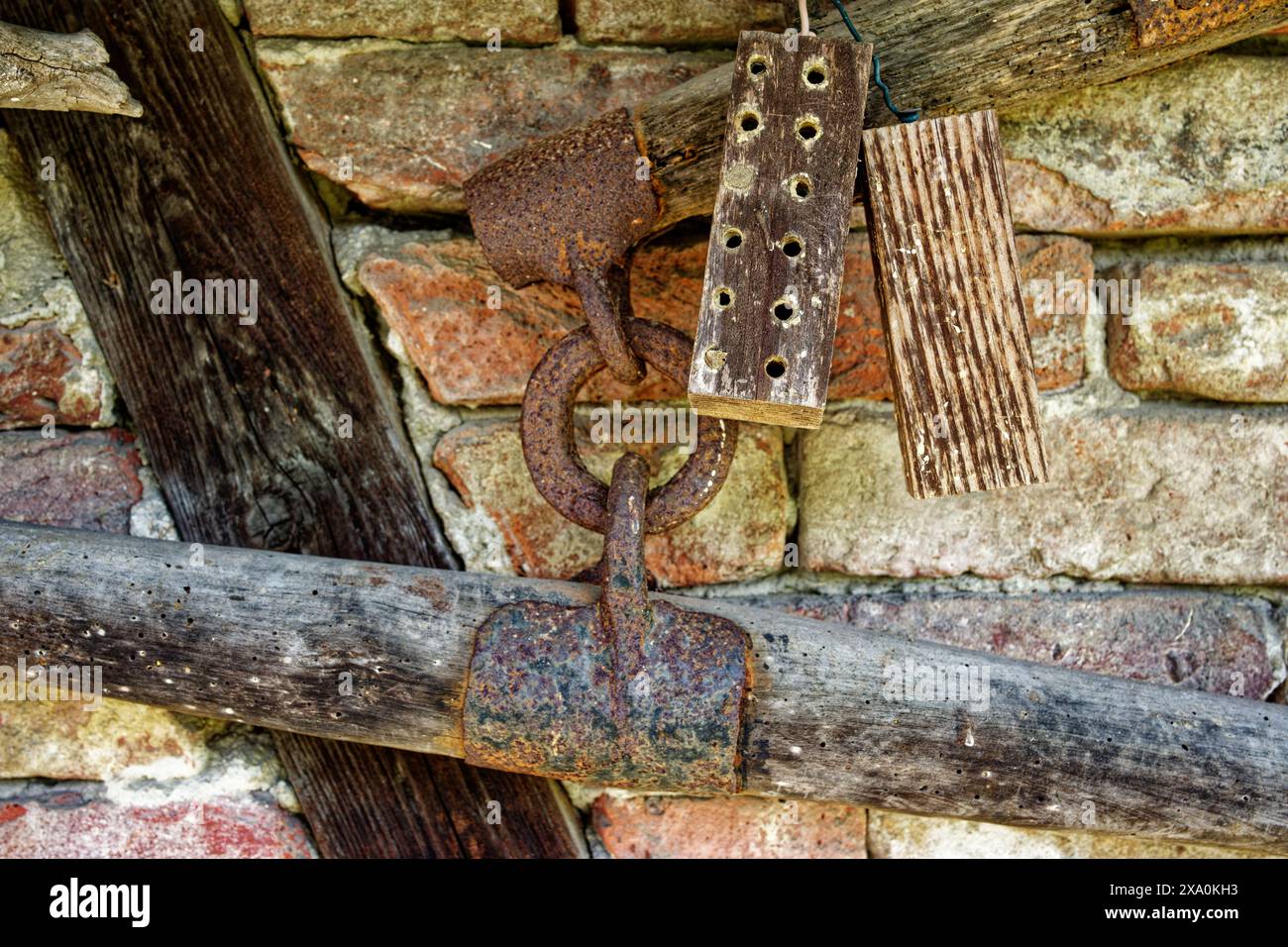 Un piccolo hotel di insetti appeso a un muro di pietra rustico Foto Stock