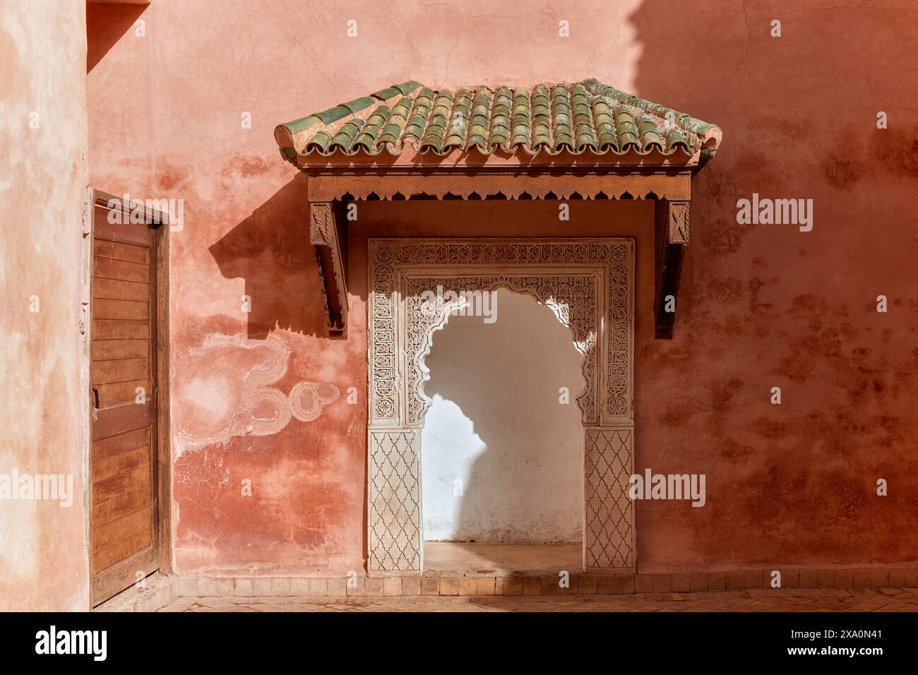 Arco marocchino con tetto piastrellato verde con bordi smerlati. Foto Stock