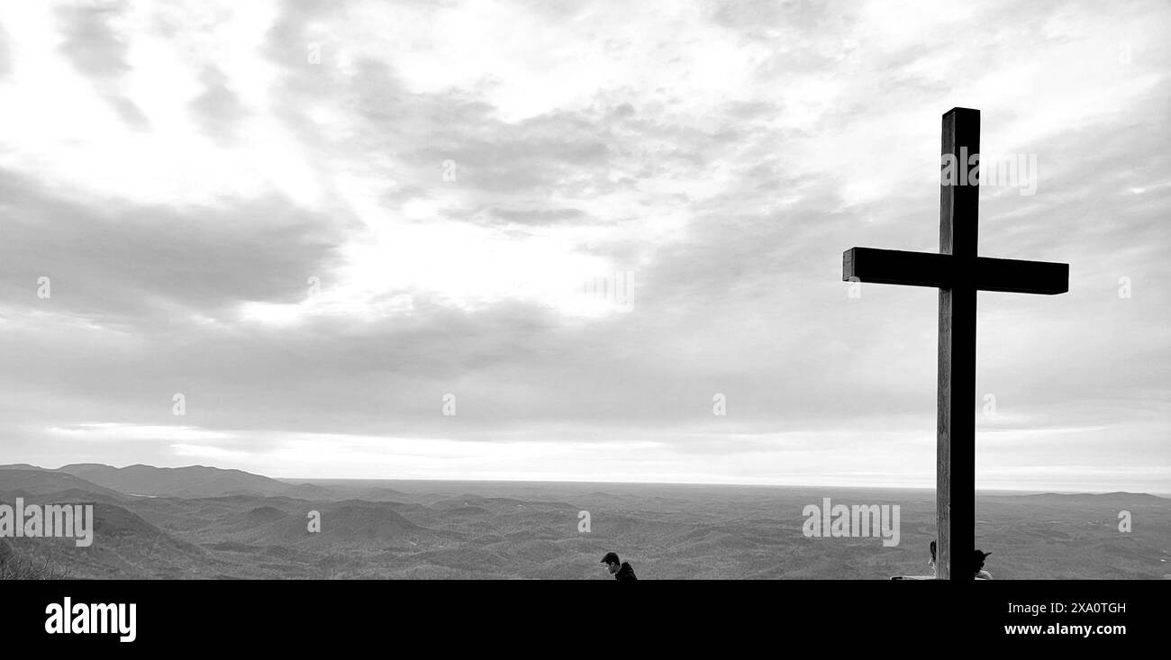 Un gruppo di individui si è riunito intorno a una croce in cima a una collina durante il weekend di Pasqua Foto Stock