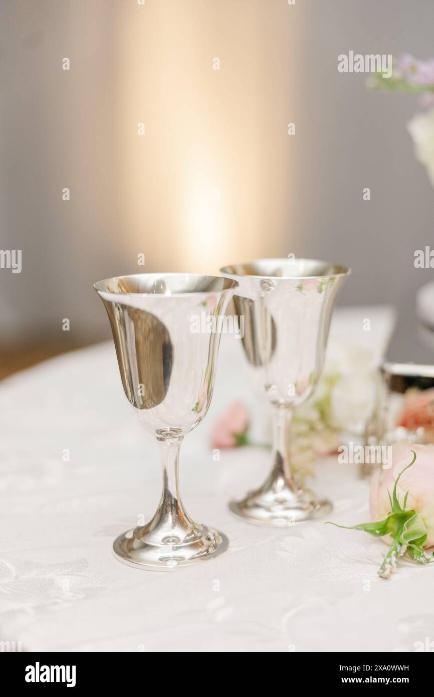Un tavolo per ricevimenti nuziali decorato con bicchieri da champagne e composizioni floreali Foto Stock