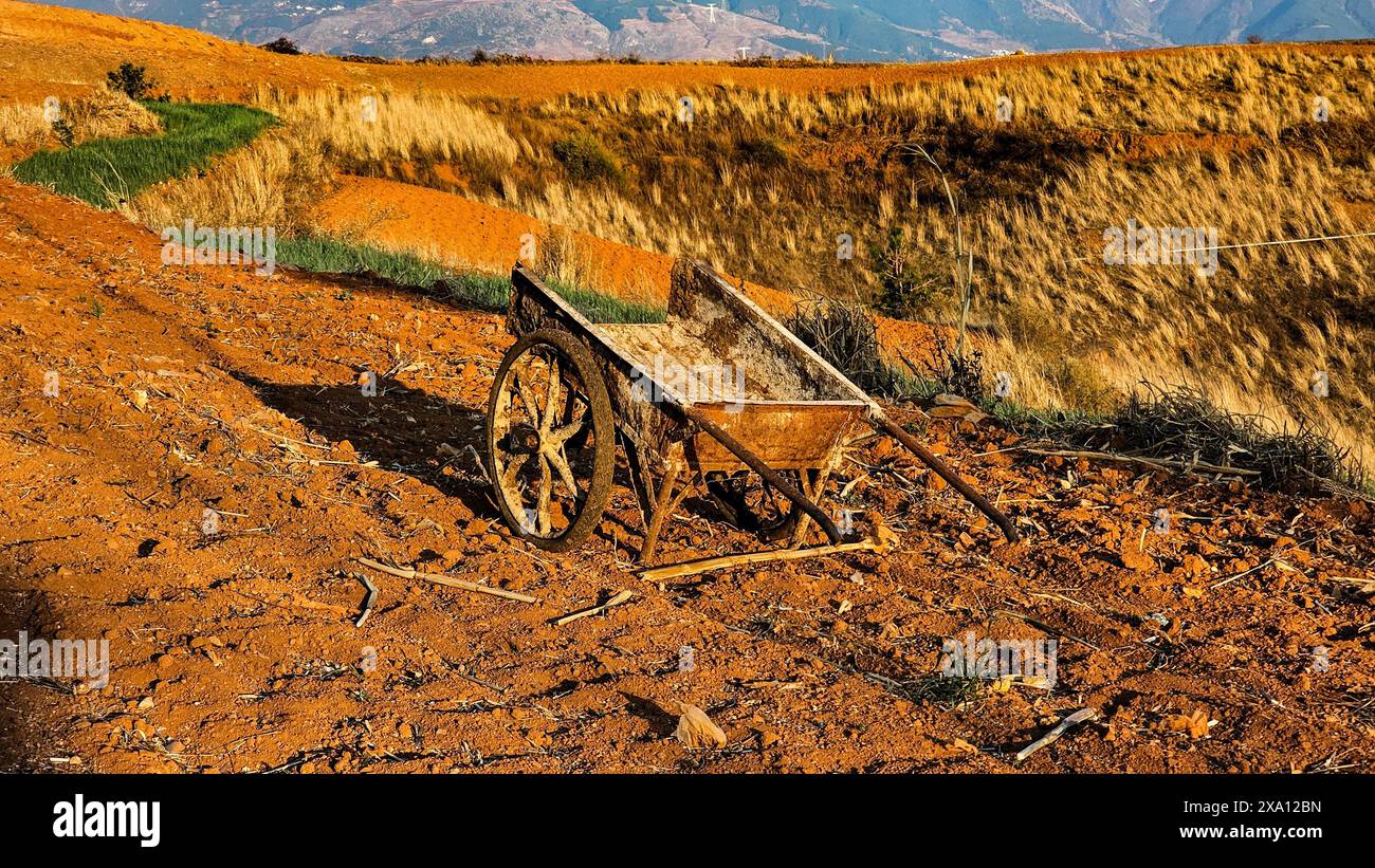Un antico carro poggia su un sentiero polveroso con montagne sullo sfondo a Wa Fang Liang Zi China Foto Stock