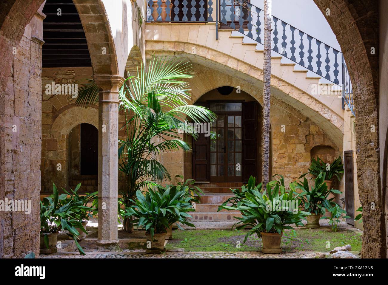 Arcata che conduce al giardino con piante e decorazioni Foto Stock