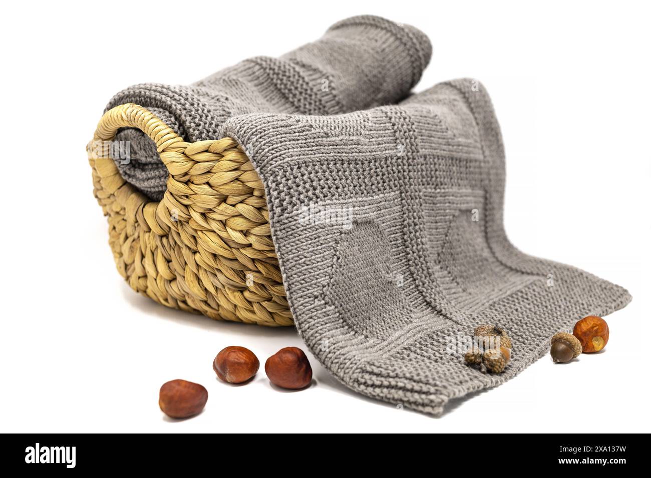 fotografia di una coperta marrone in lana lavorata a mano con motivo a maglia cuori in un cestello isolato su sfondo bianco Foto Stock