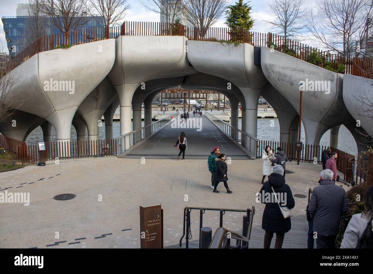 Un gruppo di individui che camminano sotto un arco, cercando una direzione Foto Stock