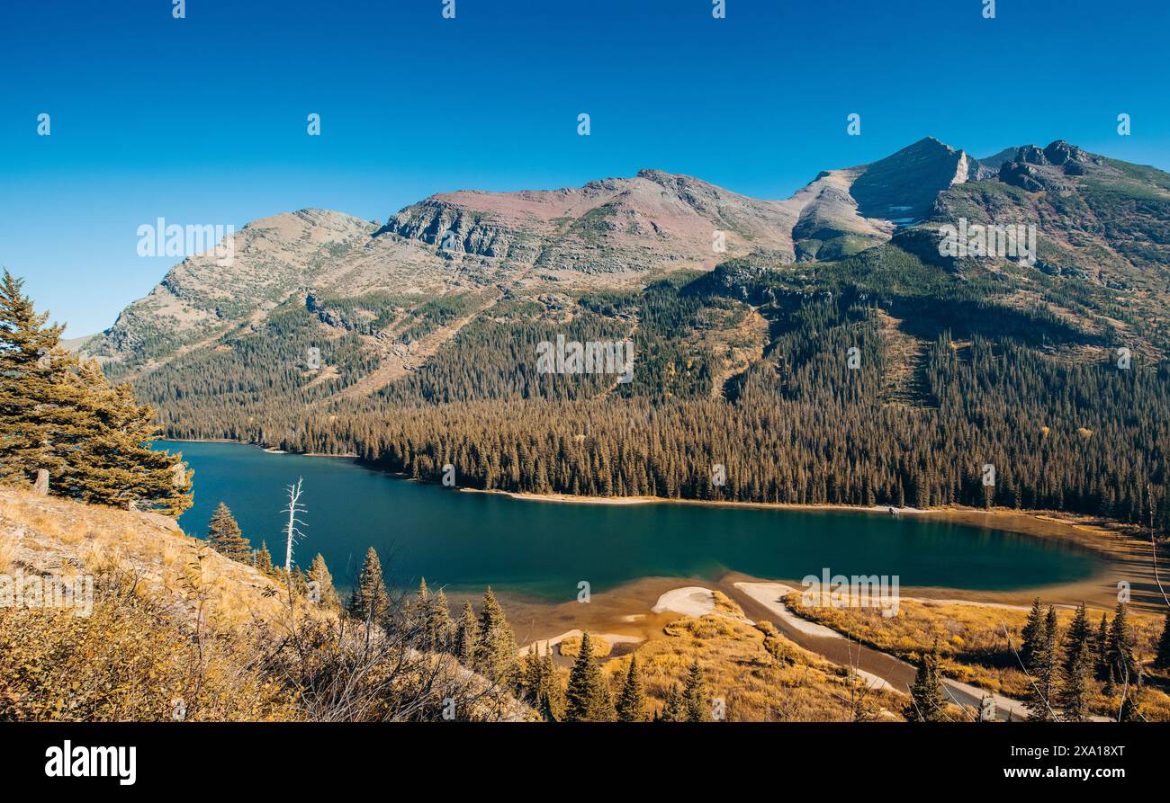 Un lago circondato dall'erba, con vista sulle montagne Foto Stock