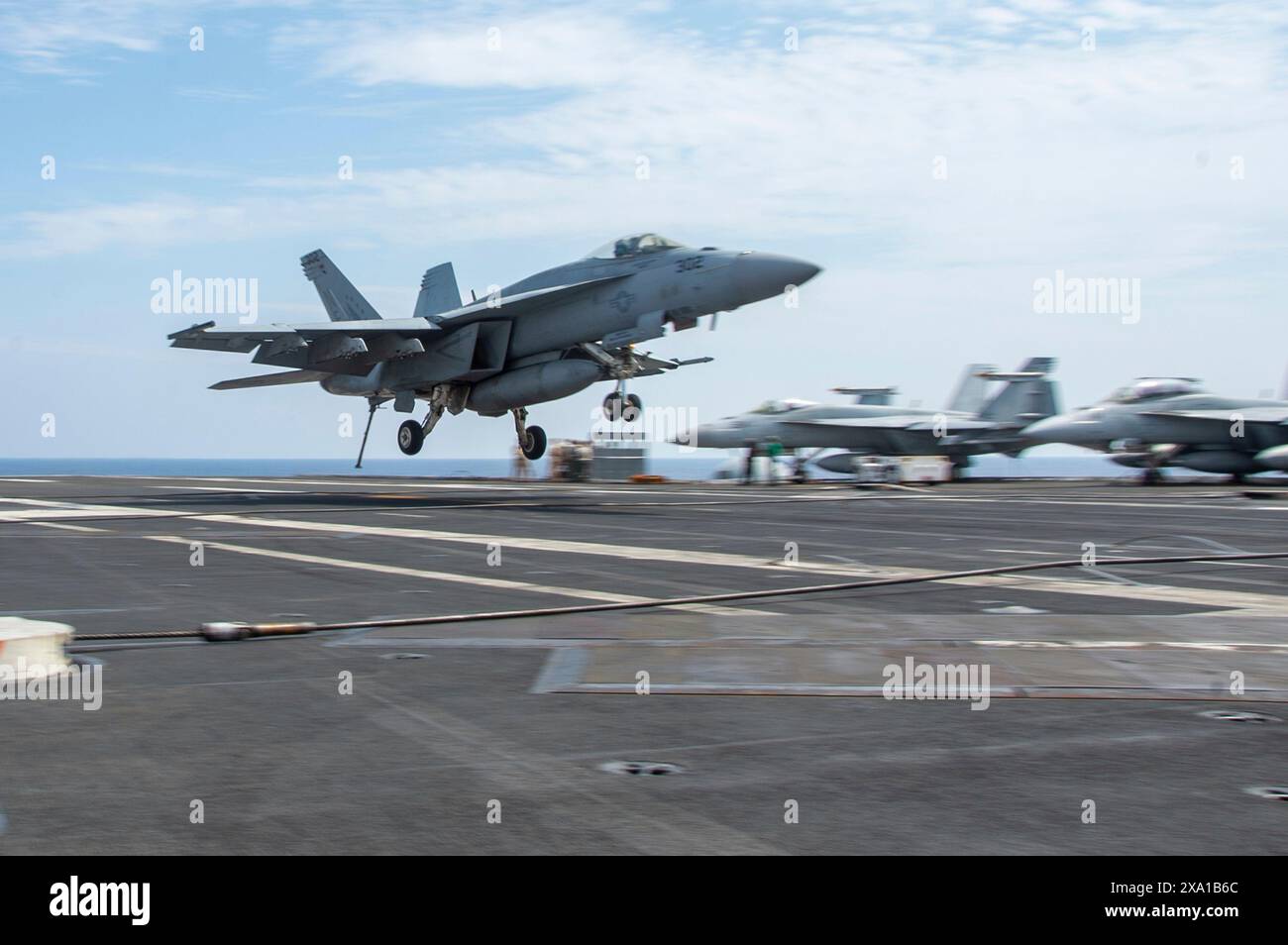 USS Ronald Reagan, Giappone. 2 giugno 2024. Un caccia F/A-18E Super Hornet della Marina degli Stati Uniti, attaccato allo Eagles of Strike Fighter Squadron 115, arriva per un atterraggio arrestato sul ponte di volo della super portaerei a propulsione nucleare della classe Nimitz, la USS Ronald Reagan durante le operazioni di volo, il 2 giugno 2024, sul Mar delle Filippine. Crediti: MC3 Eric Stanton/US Navy Photo/Alamy Live News Foto Stock