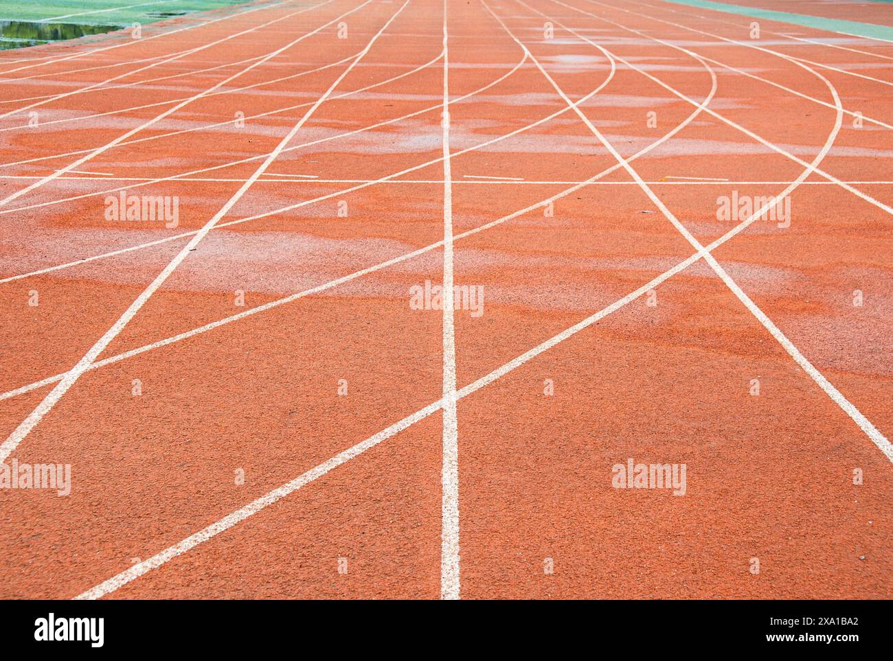 La pista rossa brillante intreccia la traiettoria bianca diritta con la traiettoria bianca curva. Foto Stock