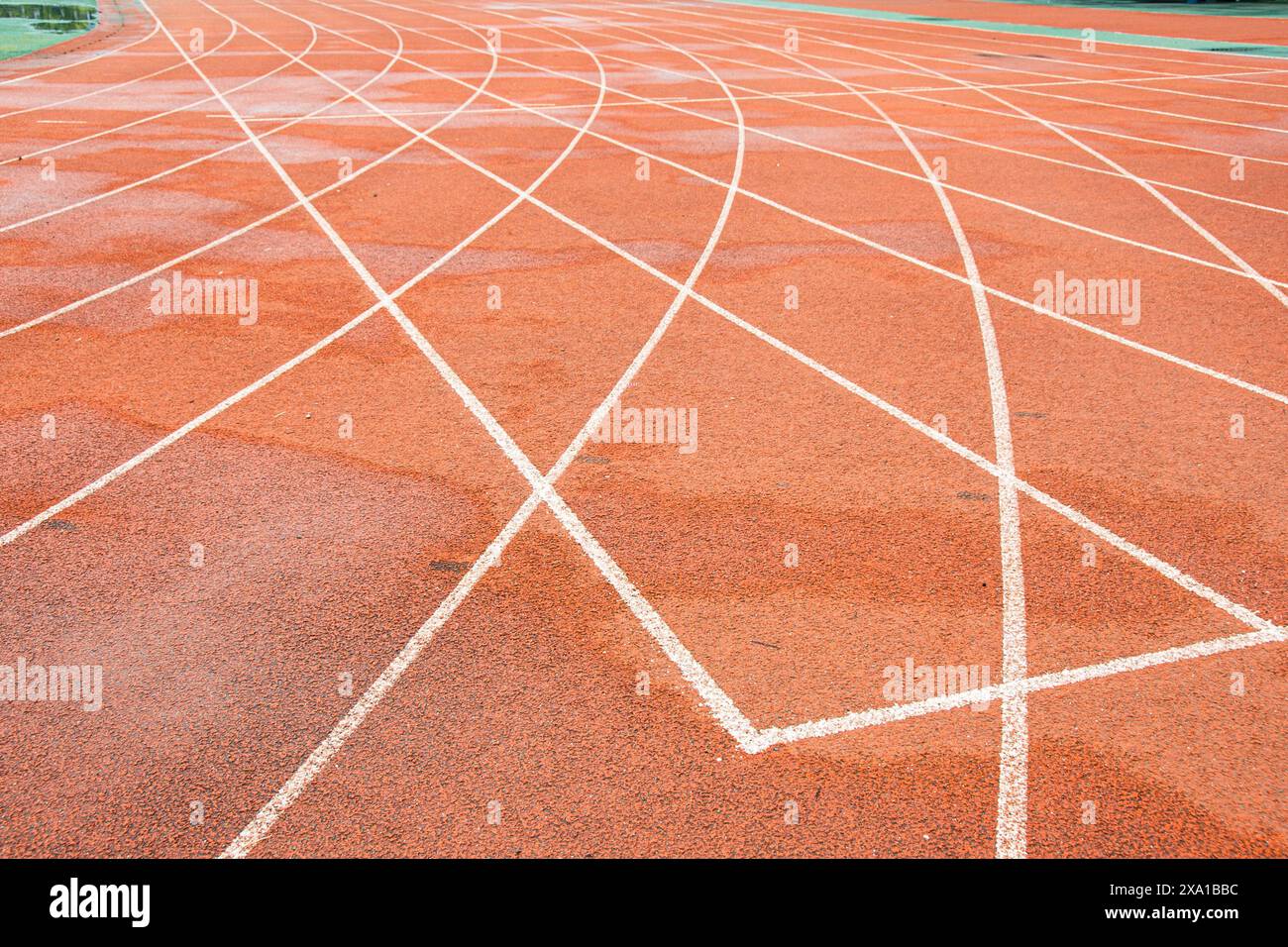 La pista rossa brillante intreccia la traiettoria bianca diritta con la traiettoria bianca curva. Foto Stock