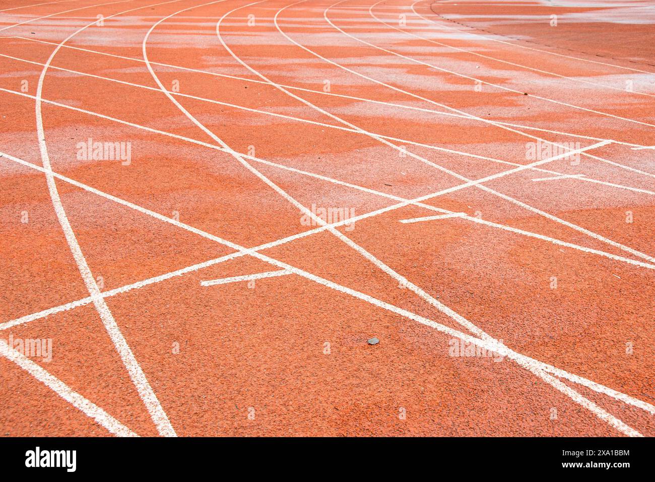 La pista rossa brillante intreccia la traiettoria bianca diritta con la traiettoria bianca curva. Foto Stock