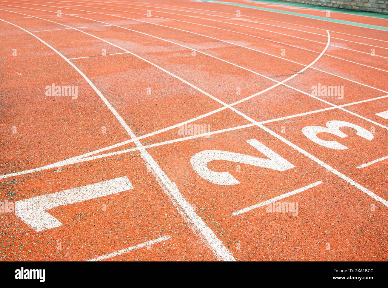 Una passerella rossa brillante con numeri bianchi stampati sulla linea di partenza. Foto Stock