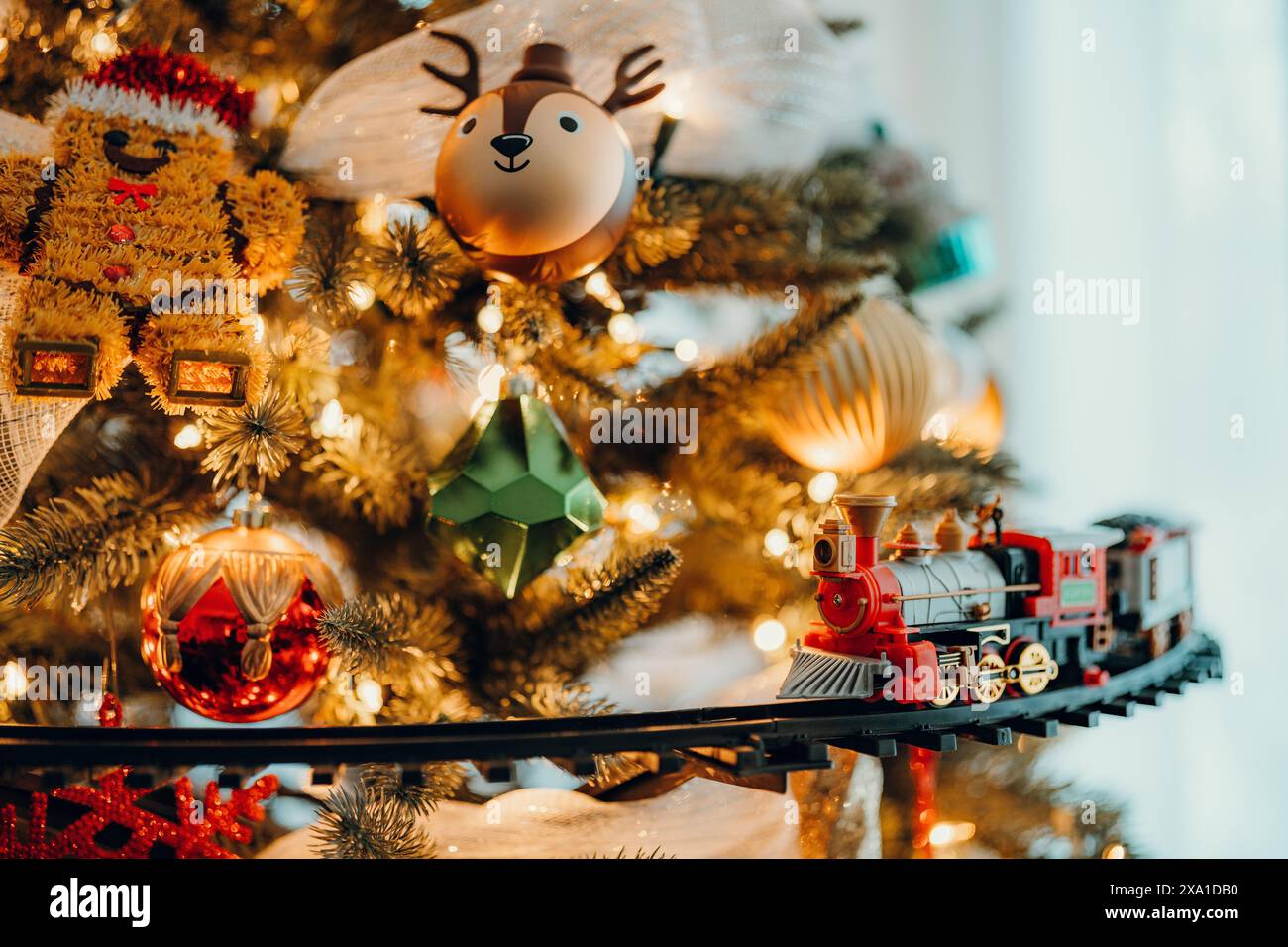 Le decorazioni natalizie appese ad un albero di Natale mentre passa un treno. Foto Stock