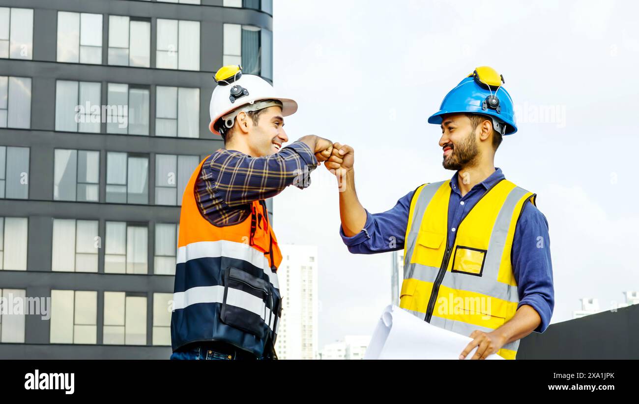 I due ingegneri stringono la mano in un ambiente urbano o industriale prima dei lavori di costruzione. Foto Stock