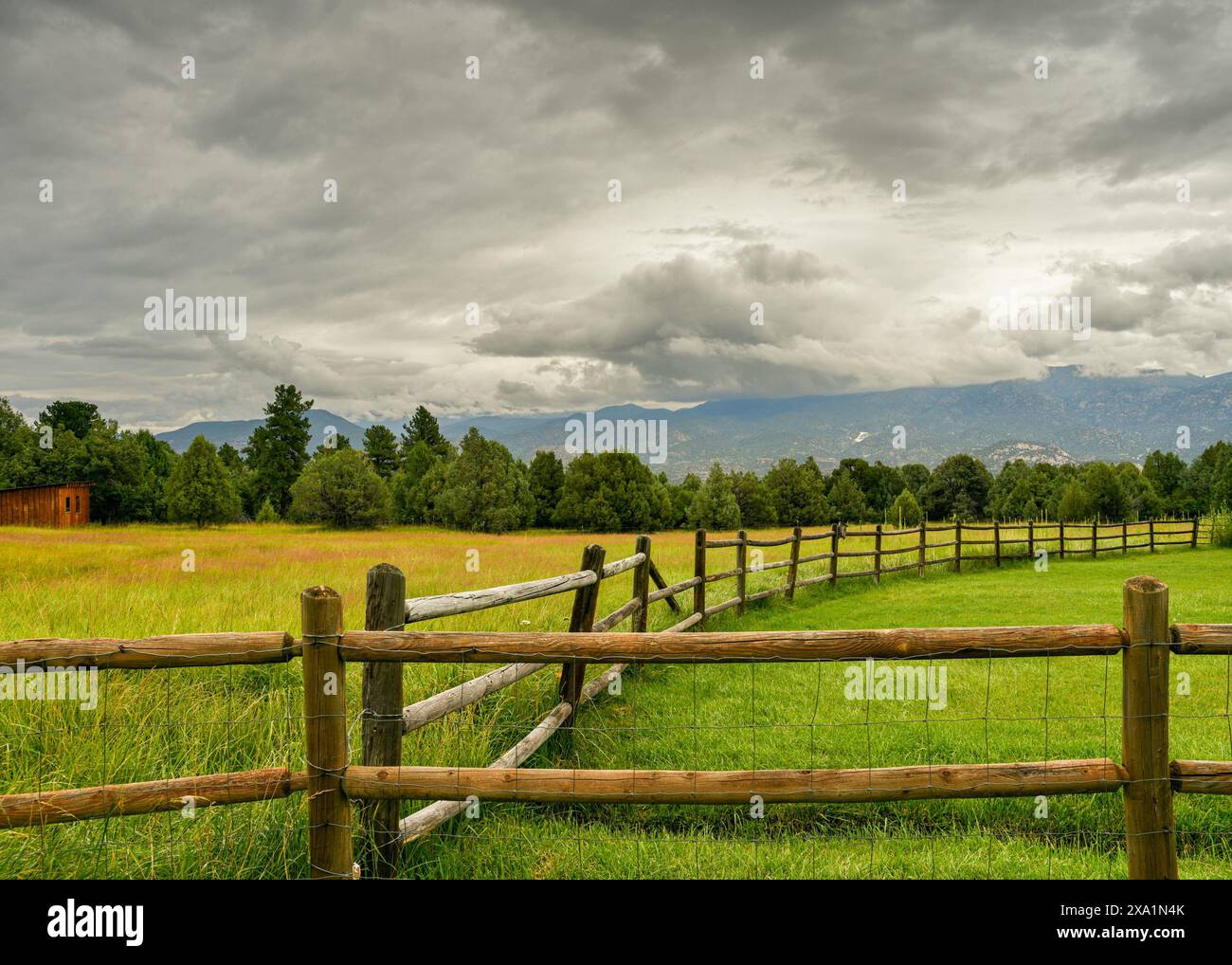 Il paesaggio rurale del Colorado con recinzione a ferrovia divisa, pascoli aperti e cieli spettacolari Foto Stock