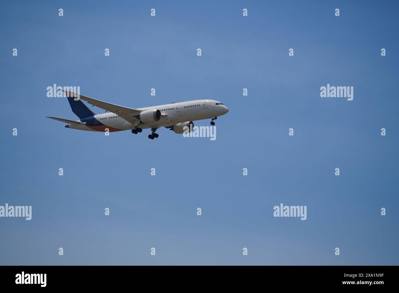 L'aereo sta volando in cielo con il carrello di atterraggio in basso Foto Stock
