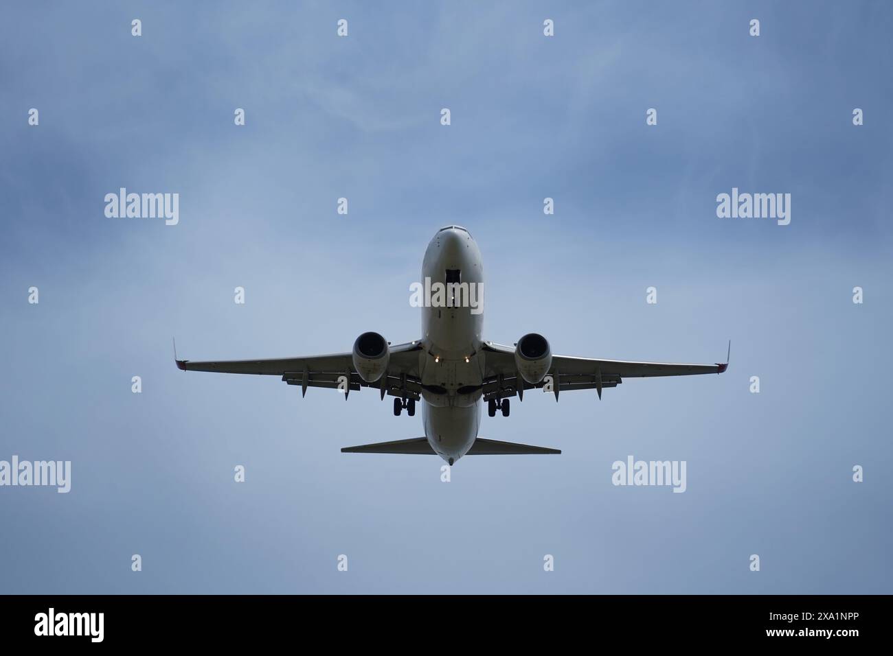 L'aereo sta volando in cielo con il carrello di atterraggio in basso Foto Stock