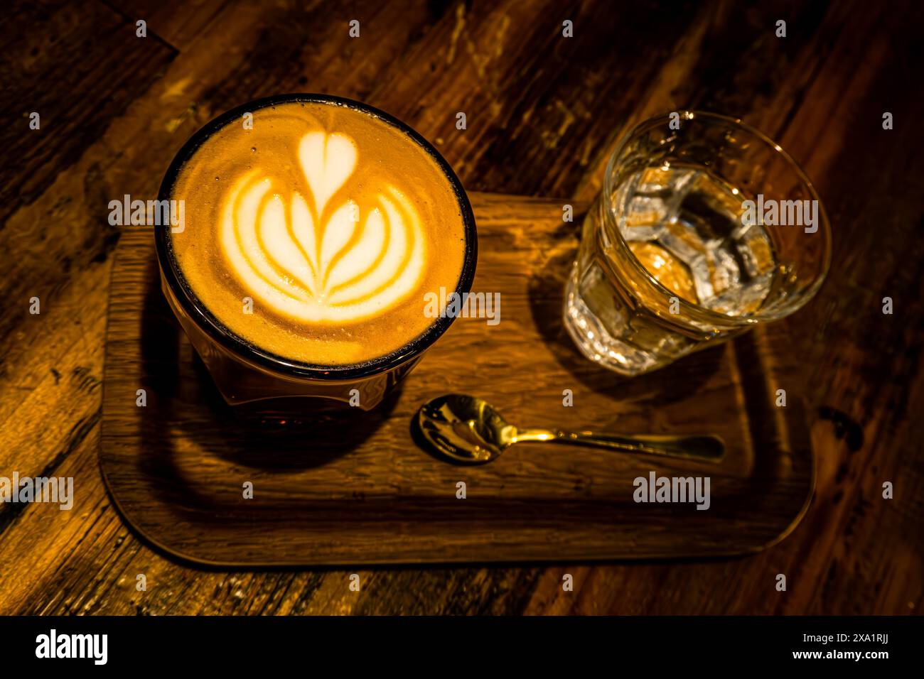 Un vassoio di legno con tazze per cappuccino e acqua Foto Stock