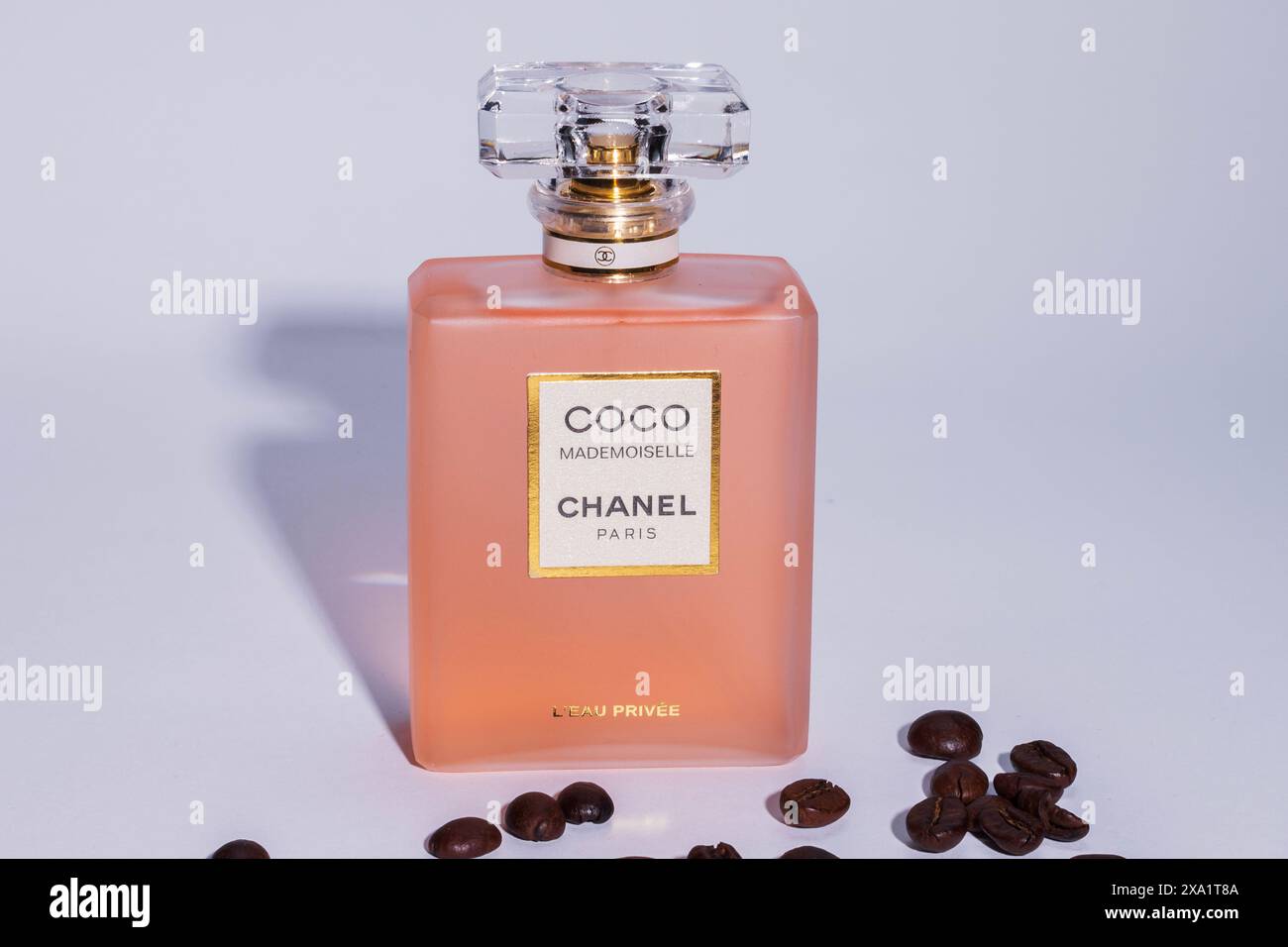 Bottiglia di profumo con chicchi di caffè su un tavolo bianco Foto Stock