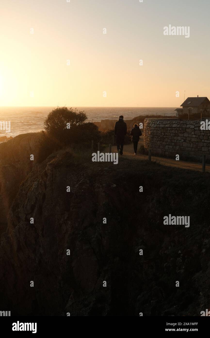 Un gruppo di individui in piedi sulla scogliera che si affaccia sull'oceano Foto Stock