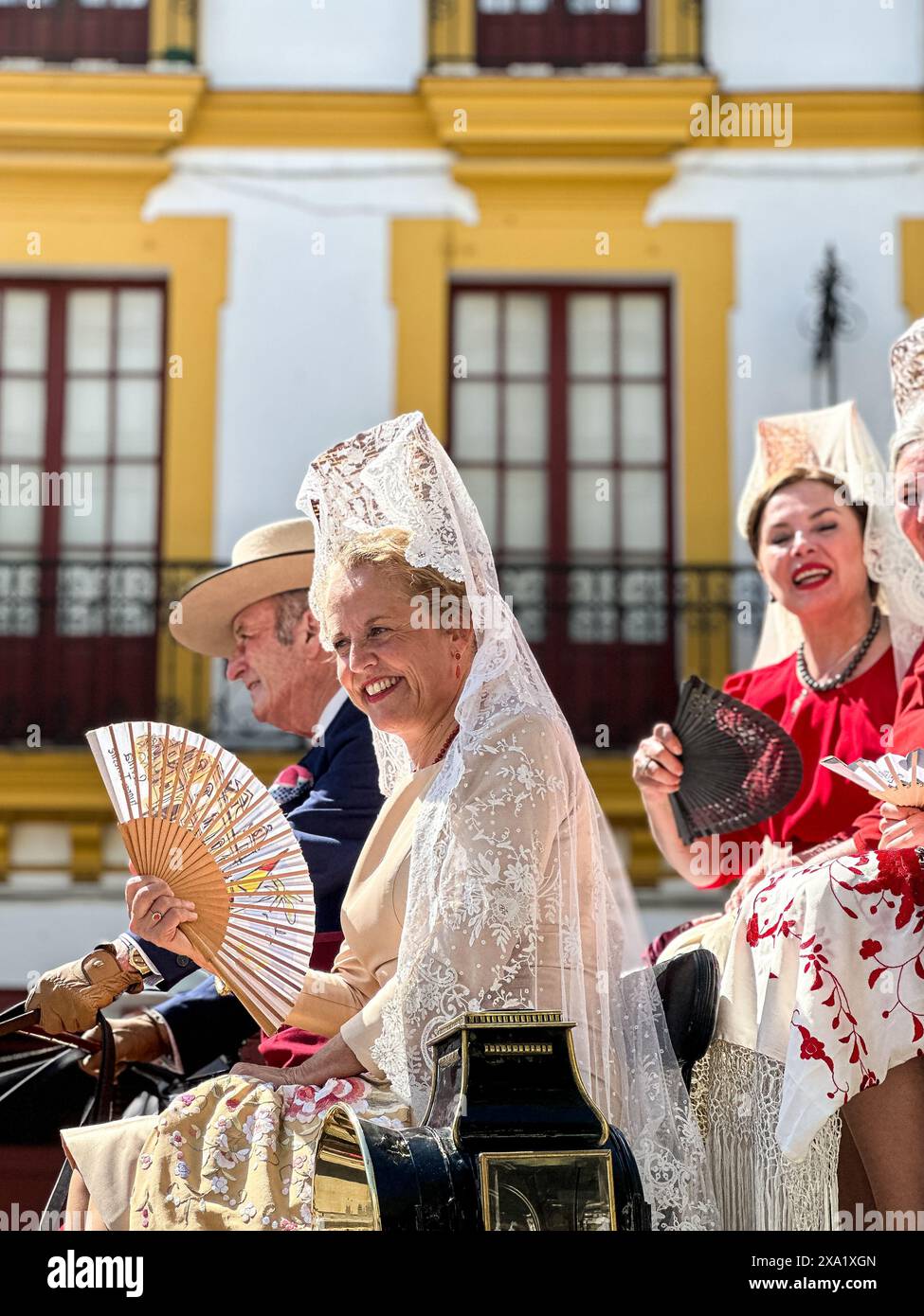 Donne in abiti tradizionali di flamenco su una carrozza trainata da cavalli alla Feria de Abril, nota anche come la Fiera di Siviglia Foto Stock