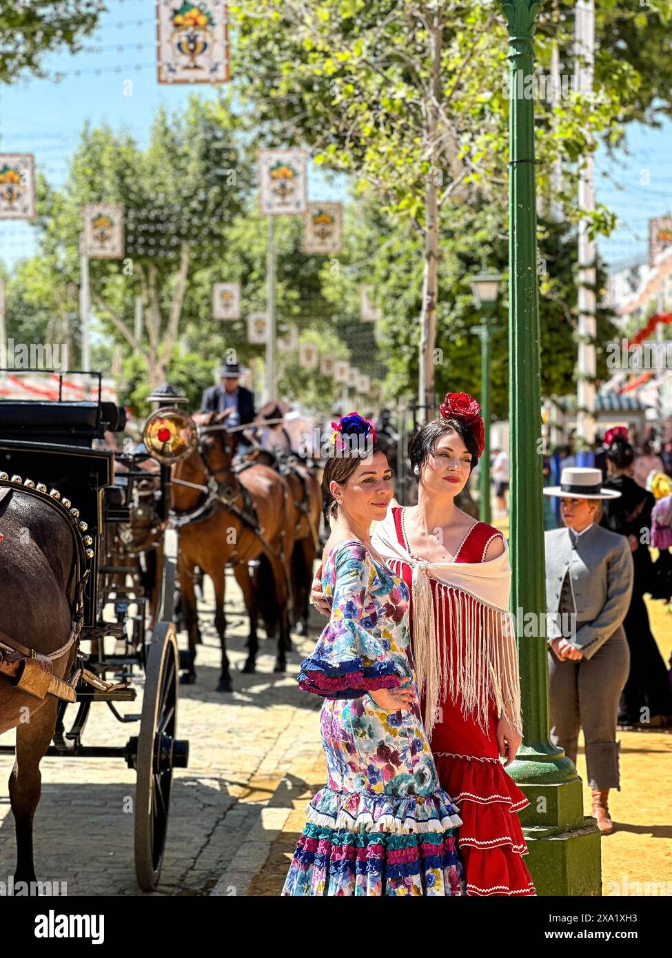 Donne in abiti tradizionali di flamenco su una carrozza trainata da cavalli alla Feria de Abril, nota anche come la Fiera di Siviglia Foto Stock