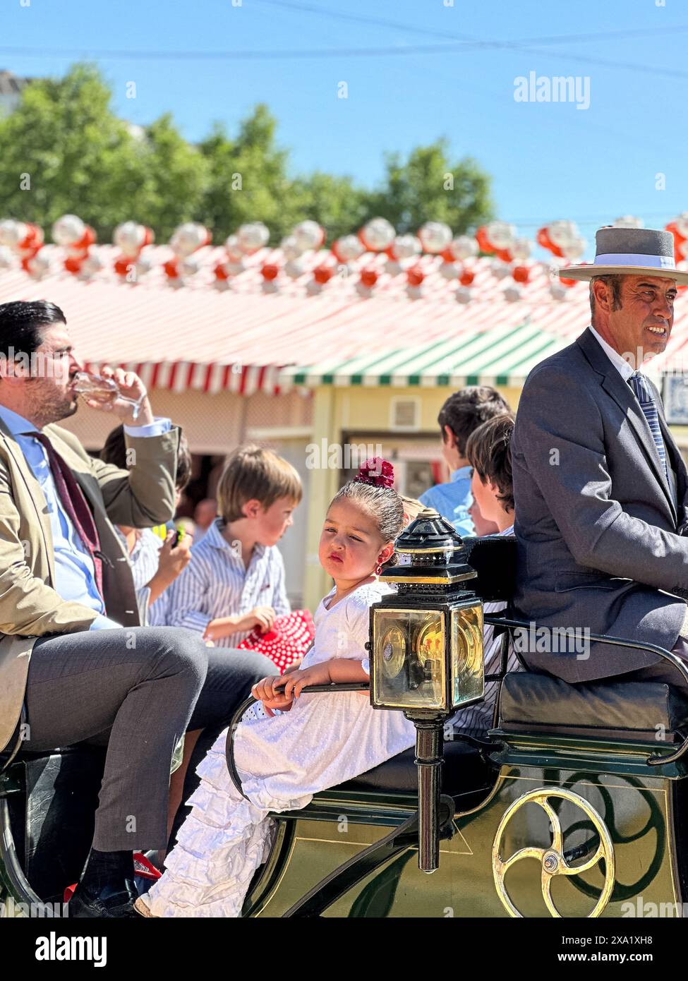 Donne in abiti tradizionali di flamenco su una carrozza trainata da cavalli alla Feria de Abril, nota anche come la Fiera di Siviglia Foto Stock
