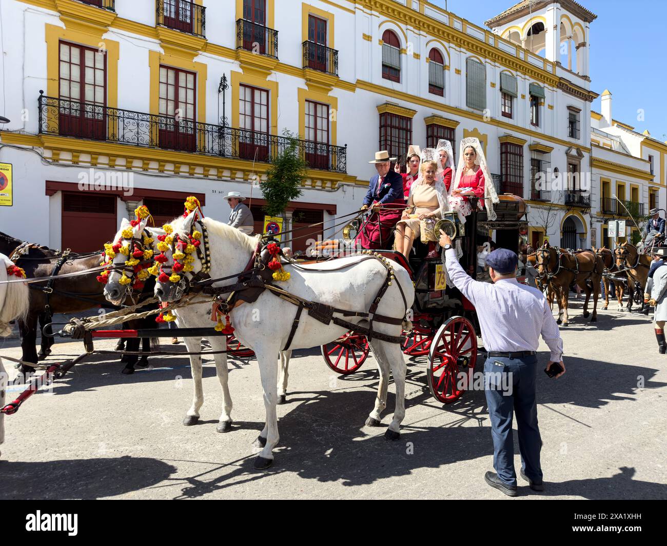 Donne in abiti tradizionali di flamenco su una carrozza trainata da cavalli alla Feria de Abril, nota anche come la Fiera di Siviglia Foto Stock