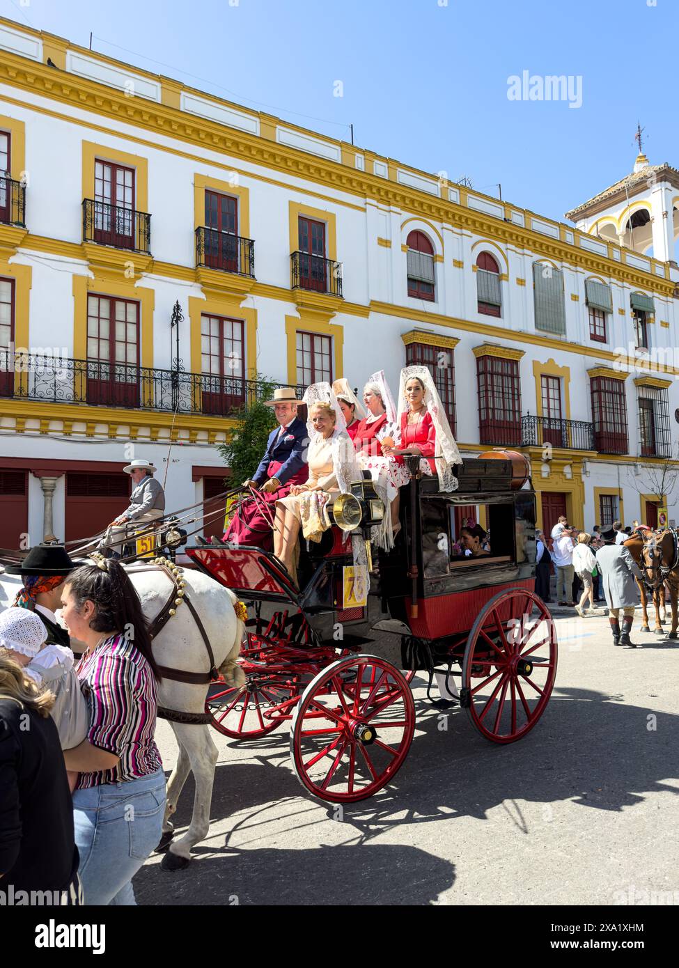 Donne in abiti tradizionali di flamenco su una carrozza trainata da cavalli alla Feria de Abril, nota anche come la Fiera di Siviglia Foto Stock