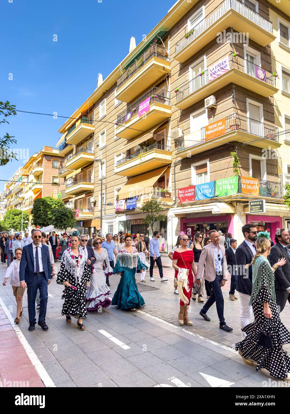 La gente che cammina verso il cancello d'ingresso è conosciuta come la Portada della Feria de Abril a Siviglia, Spagna Foto Stock