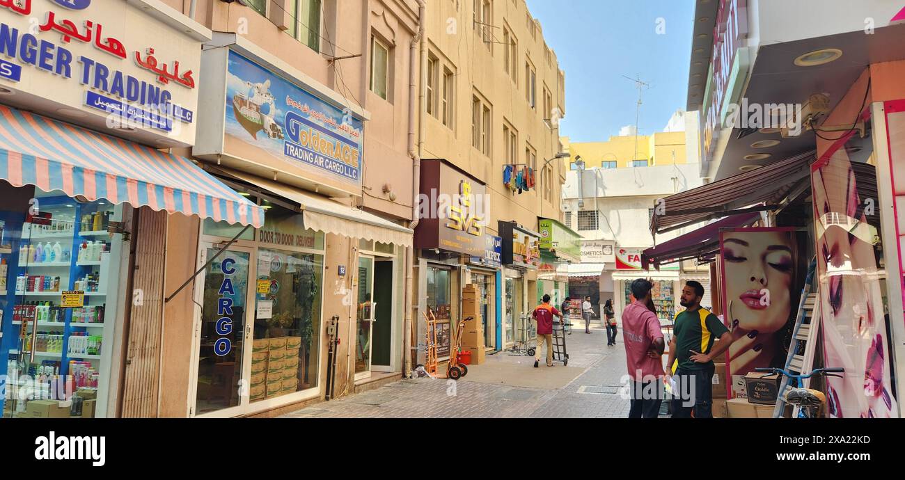 La folla passeggiava lungo la strada urbana con negozi ed edifici sullo sfondo Foto Stock