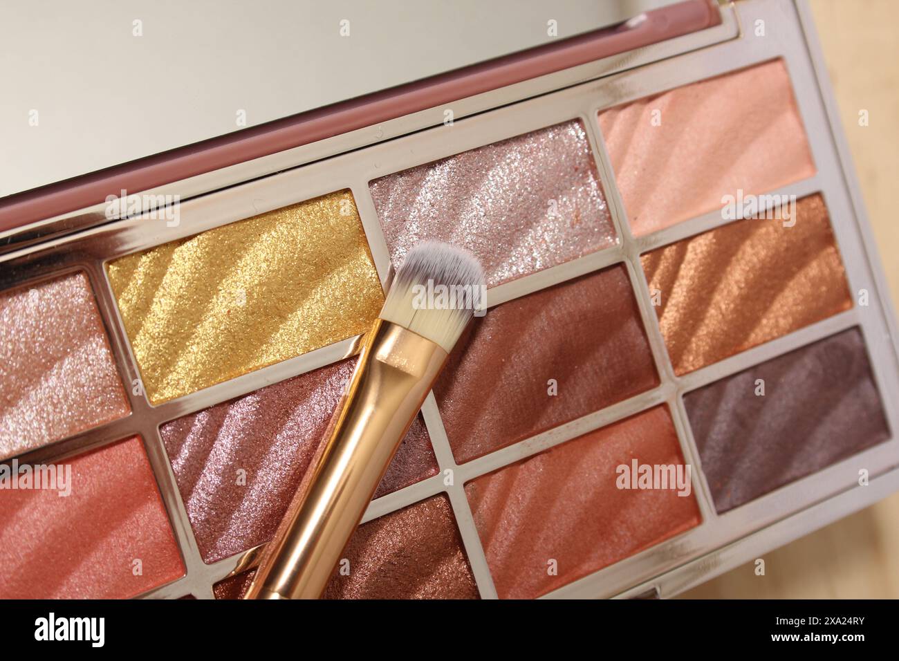 Primo piano di un pennello per il trucco accanto a una tavolozza di ombre Foto Stock