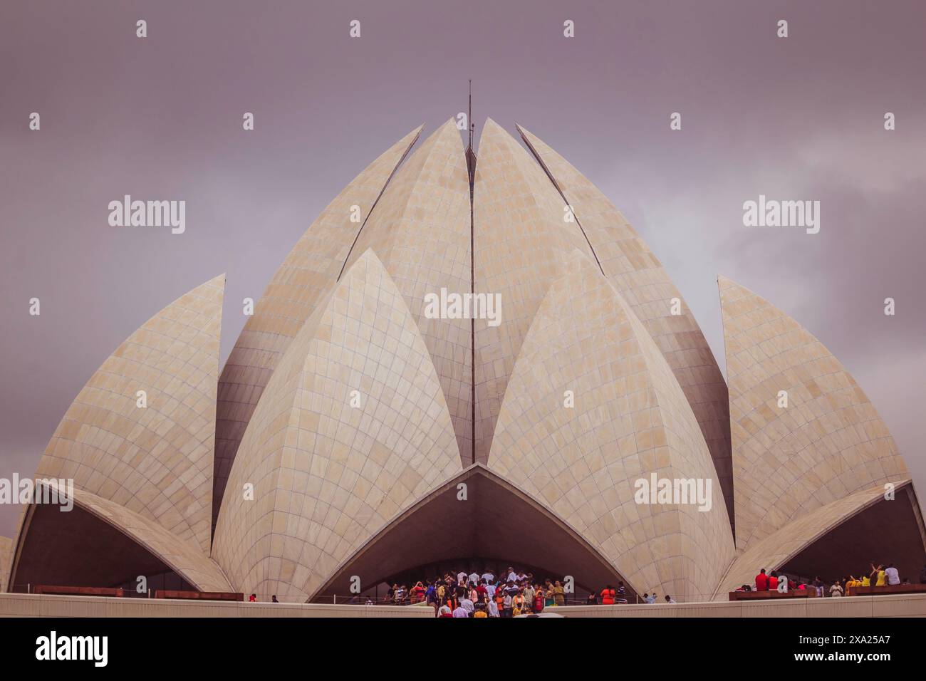 Un gruppo di individui si riunì fuori da un edificio a forma di loto in India Foto Stock