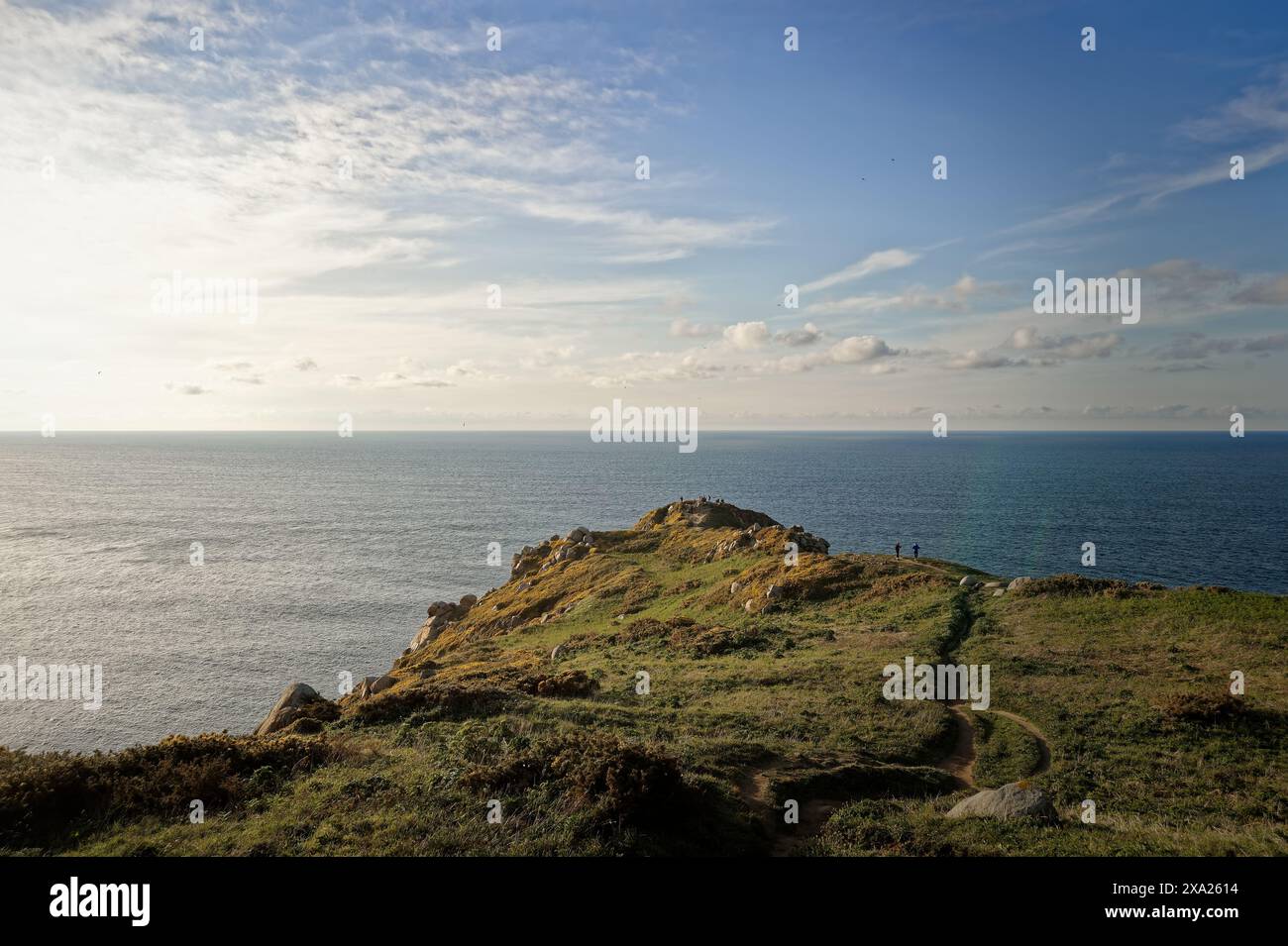 Due persone in piedi su un picco di montagna che si affaccia sull'oceano Foto Stock