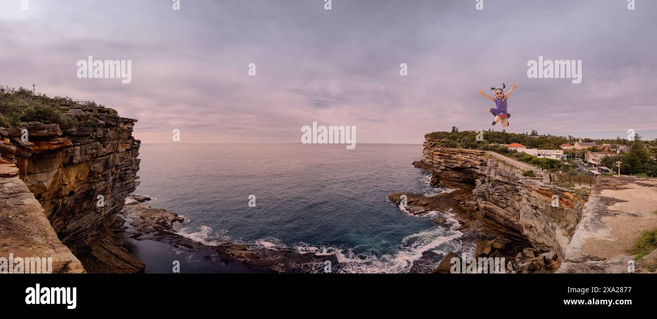 Un uomo che salta a mezz'aria sull'acqua da una scogliera Foto Stock