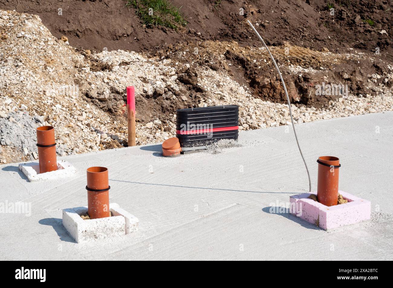 I collegamenti tra la casa e le fognature in una lastra di cemento in un cantiere edile Foto Stock