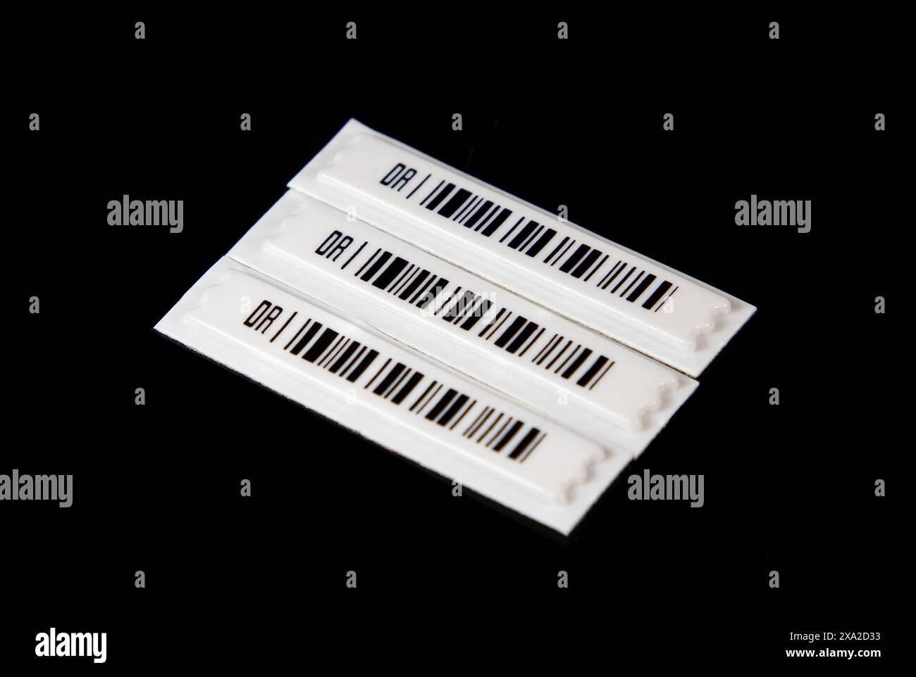 Etichette con codice a barre magnetico antifurto su sfondo nero. Foto Stock