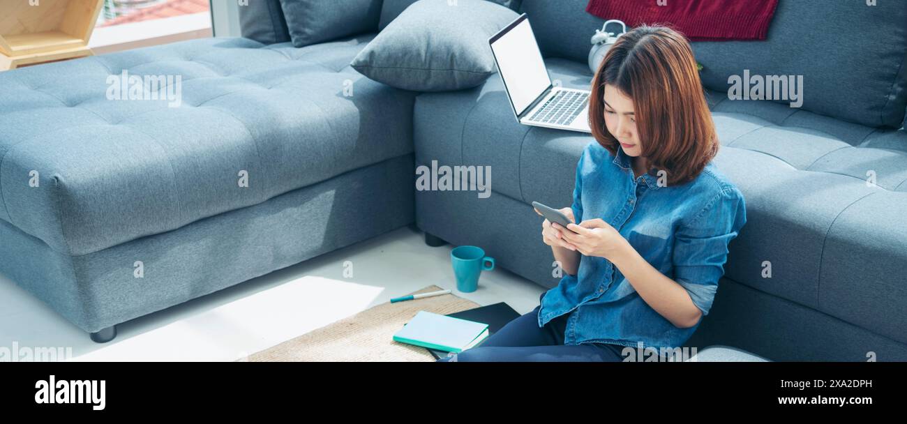 Banner donna asiatica che usa smartphone leggere online social media shopping sito web online su smartphone con il sorriso faccia. Felicità donna asiatica che tiene c Foto Stock