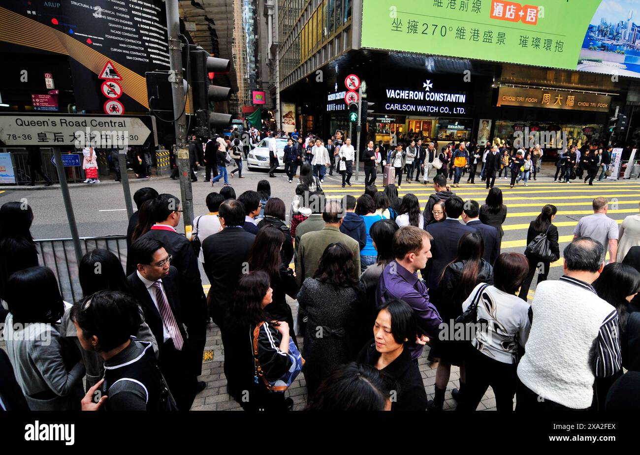 Pedoni che attraversano Queen's Road Central a Hong Kong. Foto Stock