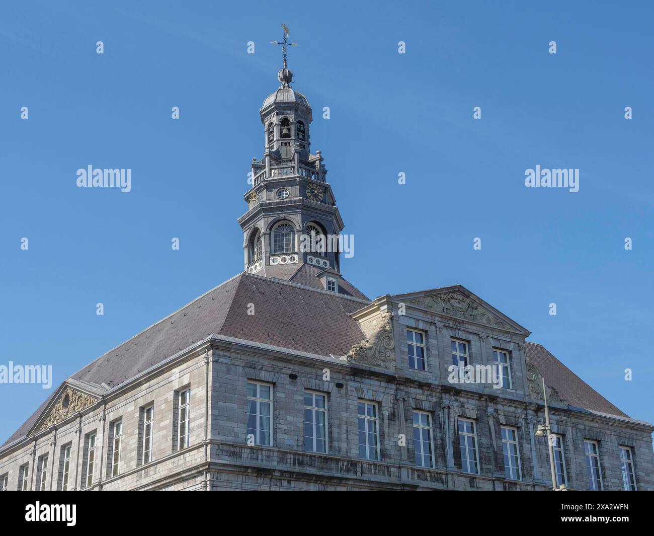 Edificio storico con un'alta torre e intricati dettagli architettonici sotto un cielo azzurro, Maastricht, Paesi Bassi Foto Stock