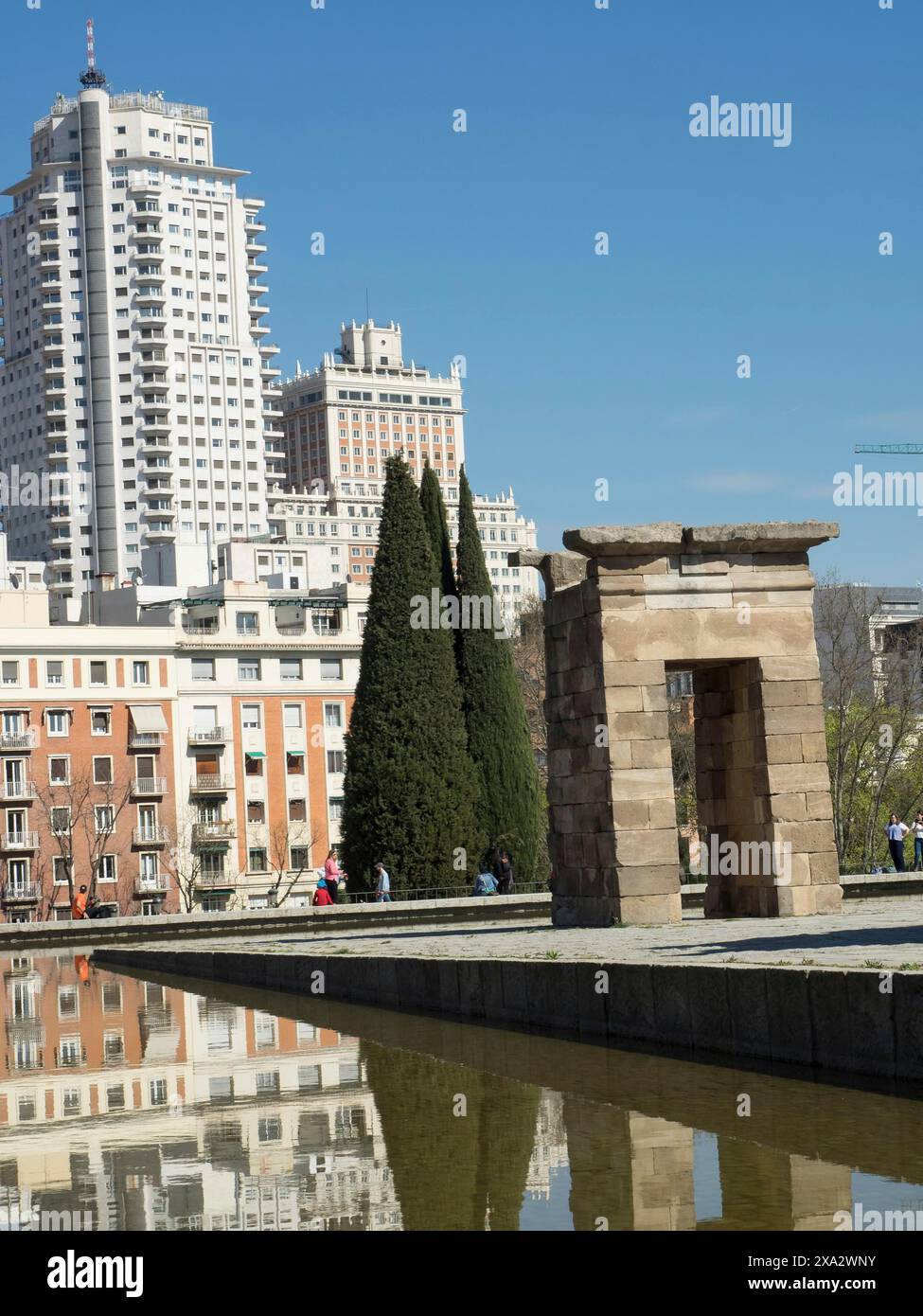 Antico tempio accanto ai moderni grattacieli con riflessi nell'acqua sotto un cielo limpido, Madrid, Spagna Foto Stock