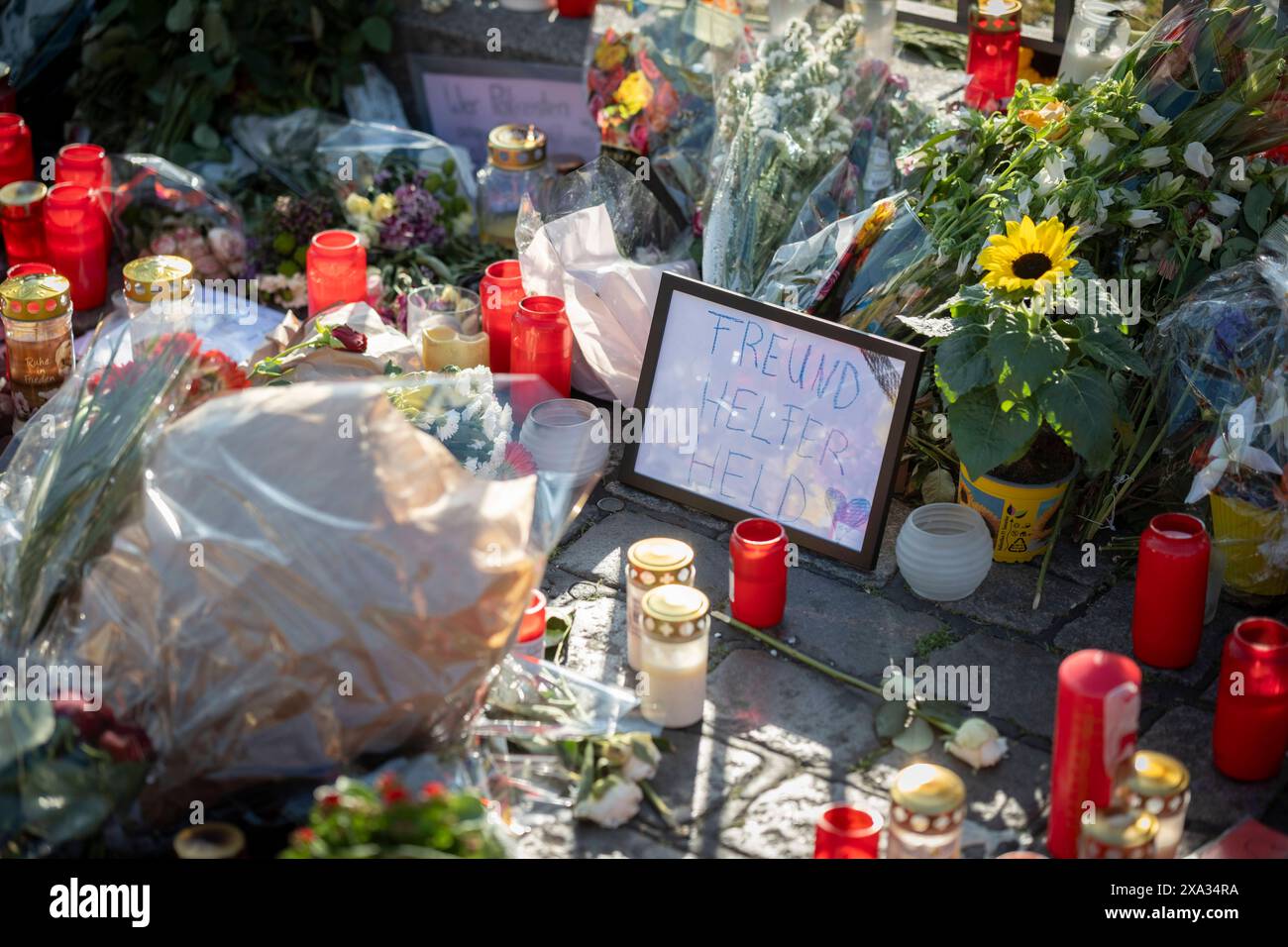 Trauer um einen 29-jaehrigen Polizeibeamten, der nach einer Messerattacke in Mannheim gestorben ist: MIT einer Kundgebung Mannheim haelt zusammen und einem interreligioesen Friedensgebet wurde seiner am Montagnachmittag auf dem Marktplatz in Mannheim gedacht im foto vom 03.und Kerort 2024: Blumen. Die Bluttat vom vergangenen Freitag Hatte bundesweit Entsetzen ausgeloest. AM 31.05.2024 hatte ein Mann auf dem Mannheimer Marktplatz mehrere Menschen mit einem langen Messer attackiert. Dabei wurden sechs Menschen zum Teil lebensgefaehrlich verletzt. Den am Sonntag gestorbenen Poliziste Foto Stock